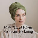 Kvinna med håret inlindat i grön hårhandduksturban från Green Heads som torkar håret skonsamt.