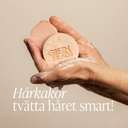 Händer som håller löddrande hårkakor från Green Heads med texten Hårkakor tvätta håret smart, bild till blogg om schampokakor och balsamkakor.