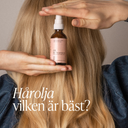 Hand som håller Green Heads hårolja Oil In Treatment framför långt blont hår med texten Hårolja vilken är bäst i bildens nedre kant.