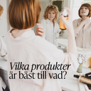 Kvinna sprayar Green Heads stylingprodukt framför badrumsspegeln och ser sitt lockiga hår i spegeln – illustration av guide till rätt hårprodukter.